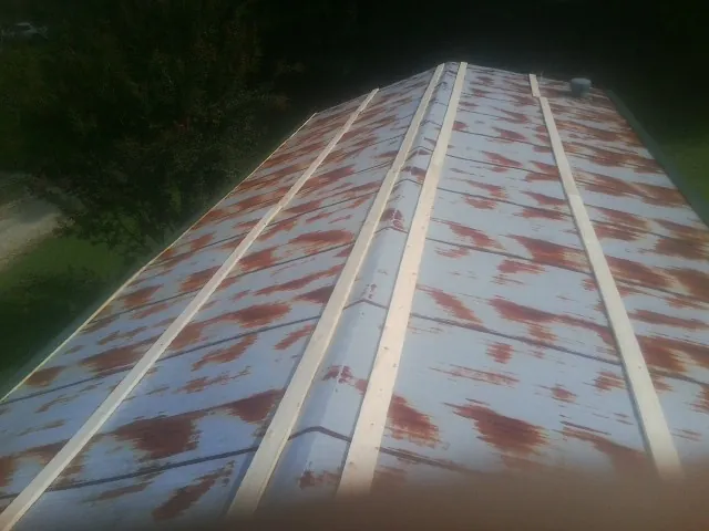 Rusted metal roof panels with new wood purlins before replacement — Storm Damage Roof Repair in Rome by Roofing Brothers