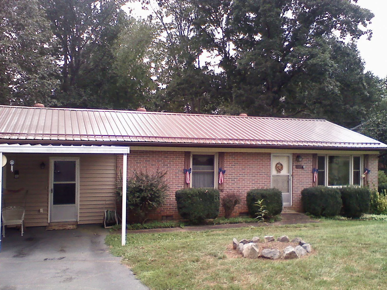 Bronze metal roof and carport on a brick ranch home — Roof Repair work by our crew in Rome